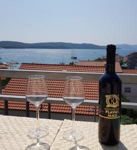 eine Flasche Wein auf einem Tisch mit zwei Gläsern in der Unterkunft Apartments Krizanac in Trogir