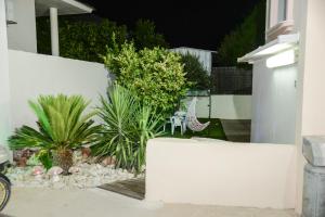 un jardín con plantas y una pared blanca en Master hosting Gal, en Beit She'an