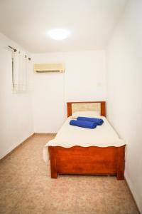 Un dormitorio con una cama con toallas azules. en Master hosting Gal en Bet Sheʼan