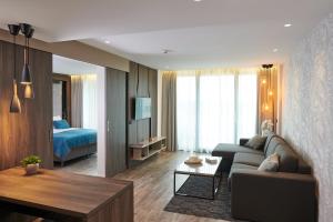 una sala de estar con un sofá y una cama en Postojna Cave Hotel Jama, en Postojna