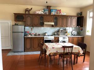 a kitchen with a table and a stove and a refrigerator at Shaki Host House in Sheki