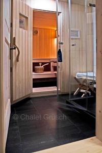 a hospital room with a glass door and a chair at Chalet Grüsch in Grüsch