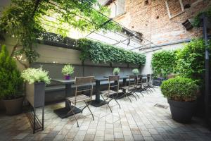un patio con un lungo tavolo con sedie e piante di Piccola Torre Maison a Vigevano