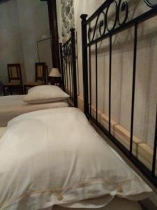 SuseganaにあるAffittacamere Civico 80の白い毛布と枕が備わる客室内のベッド2台