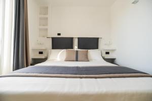 a bedroom with a large bed with white sheets and pillows at Dimora Maio in Monopoli