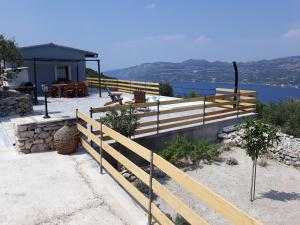 a house with a wooden fence next to the water at BELLAVISTA Luxury Lodge in Korčula