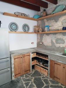 a kitchen with wooden cabinets and a stone wall at Casas del Mar in Cadaqués +17 photos