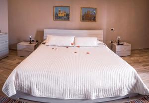 a bedroom with a large white bed with two night stands at B&b A casa di Maybe in Caserta