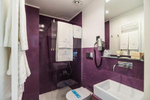 a purple bathroom with a sink and a toilet at Dimora Maio in Monopoli +40 photos
