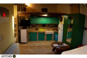 a green kitchen with green cabinets and a table at Medusa Gorgon in Develíkia