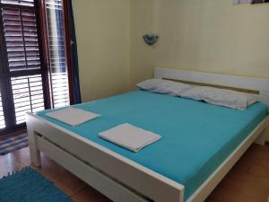 Bett in einem Zimmer mit blauer Matratze in der Unterkunft Apartments Jovic in Mali Lošinj