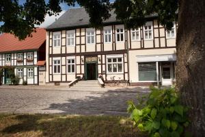 a large white building with a black roof at Landhotel Zum Pottkuchen in Kalbe