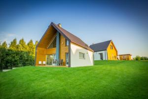 una casa su una collina con un prato verde di Jaśminowy Sad a Mikołajki