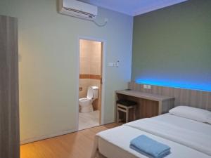 a bedroom with a bed and a bathroom with a toilet at SleepRest @ Golden Prima in Batam Center +48 photos