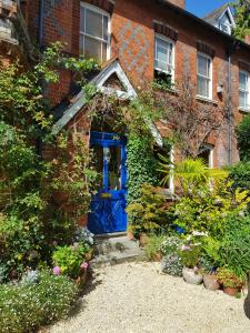 una puerta azul en el lateral de una casa de ladrillo en Alma House Bed and Breakfast en Newbury