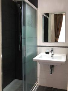 a bathroom with a sink and a glass shower at Elle Cavour Guest House in Rome +38 photos