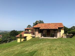a house on top of a grassy hill at Casa Collao 24 in Sierra