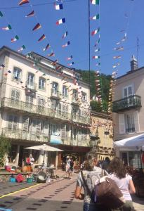 eine Gruppe von Menschen, die vor einem Gebäude spazieren in der Unterkunft Résidence Maison Blanche in Plombières-les-Bains