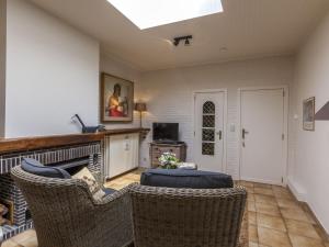uma sala de estar com lareira e cadeiras de vime em Modern Holiday Home in Zingem with Garden em Zingem