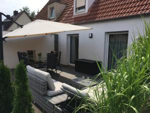 a patio with a couch and an umbrella at Ferienhaus Birkenweg in Erfurt