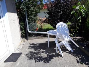 オストゼーバート・カールスハーゲンにあるFerienzimmer Schwalbennestの家の外に座る青白の椅子