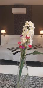 un jarrón lleno de flores sentado en una mesa en un dormitorio en Nest Flats Granada, en Granada