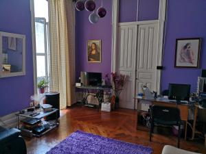 a living room with purple walls and wooden floors at Residencial S Juliao AL in Figueira da Foz