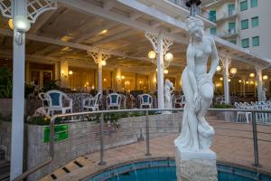 una estatua de una mujer parada junto a una piscina en Grand Hotel Excelsior, en Senigallia