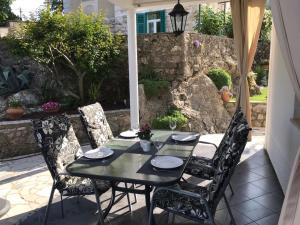 a table and chairs sitting on a patio at Apartments Mirna with parking in Lovran