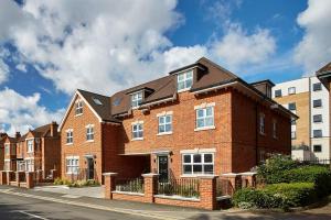 una casa de ladrillo rojo con techo negro en Imperial Court By Viridian Apartments, en Maidenhead