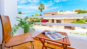 Un balcón con una mesa y un libro. en Casa GAVINES Alcudia en Playa de Muro