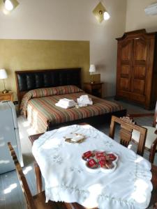 CalossoにあるL'Antico Fienileのベッドルーム1室(ベッド1台、テーブル、食べ物付)