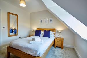 a bedroom with a bed with blue pillows and a mirror at Imperial Court By Viridian Apartments in Maidenhead