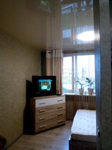 リヴィウにあるVIP Квартираのベッドルーム(テレビ付)、ドレッサー、窓