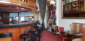 un bar dans un restaurant avec un comptoir et des tabourets dans l'établissement Rembrandtplein Hotel, à Amsterdam