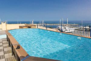 een groot zwembad met uitzicht op de oceaan bij Résidence Odalys Les Voiles Blanches in Sari Solenzara