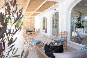 a porch with wicker chairs and a table at FERGUS Style Carema Beach in Cala en Bosc