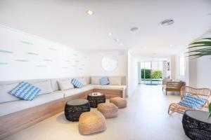 a living room with a couch and some chairs at FERGUS Style Carema Beach in Cala en Bosc