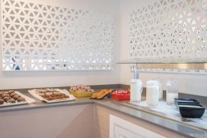 a buffet with pastries and other food on a counter at FERGUS Style Carema Beach in Cala en Bosc