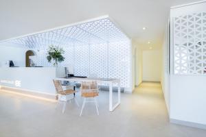 a white dining room with a white table and chairs at FERGUS Style Carema Beach in Cala en Bosc