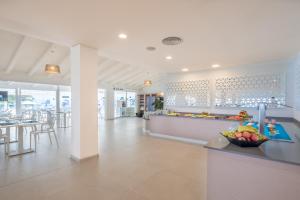 a kitchen with a counter with a bowl of fruit at FERGUS Style Carema Beach in Cala en Bosc