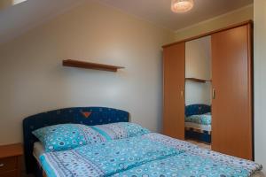 a bedroom with a blue bed and a mirror at Kwatery Prywatne Dzika Roza in Darłowo