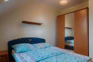 a bedroom with a blue bed and a mirror at Kwatery Prywatne Dzika Roza in Darłowo +52 photos
