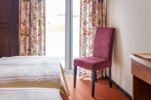 a room with a bed, chair and a window at Catolica Hotel in Fátima