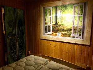 a bedroom with a window and a bed in it at Holzhaus Trollblümchen am Wald und See in Neuruppin