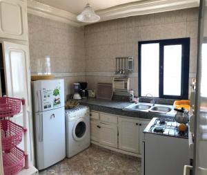 een keuken met een witte koelkast en een vaatwasser bij Appartement Palm Beach in Mohammedia