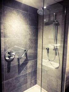 ducha con puerta de cristal y aseo en Maldron Hotel Belfast City, en Belfast