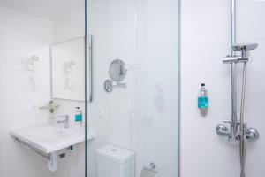 a bathroom with a shower and a sink and a toilet at FERGUS Style Carema Beach in Cala en Bosc