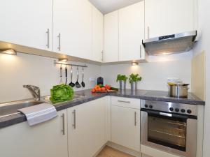 a kitchen with white cabinets and a sink at Sonnenstern in Riezlern