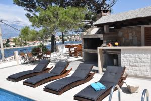 a group of lounge chairs next to a swimming pool at Villa Sky with stunning view in Selca